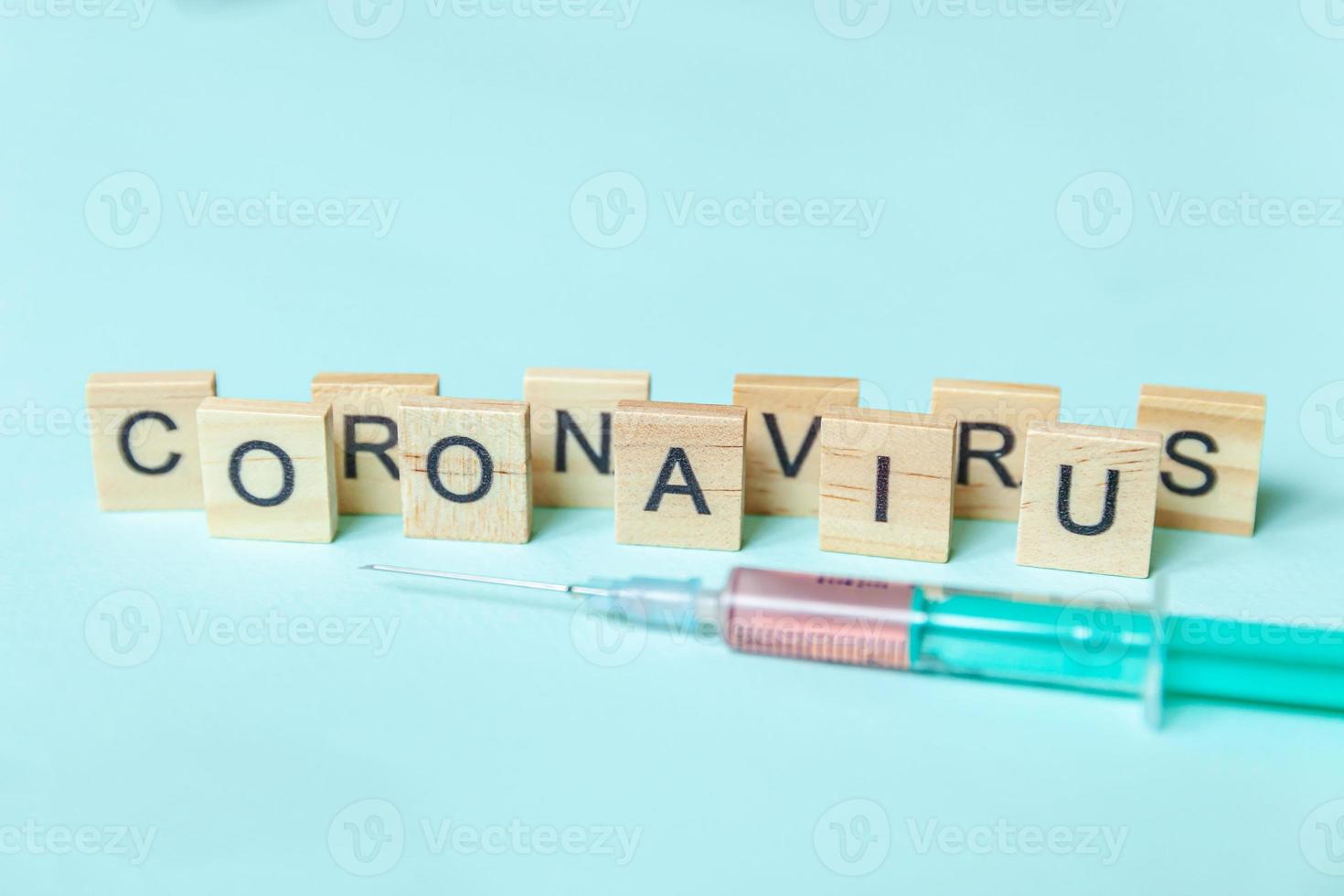 textphrase coronavirus und spritze auf blauem pastellhintergrund. neuartiges coronavirus 2019-ncov mers-cov covid-19 respiratorisches syndrom des nahen ostens coronavirus-virus-impfstoffkonzept. foto