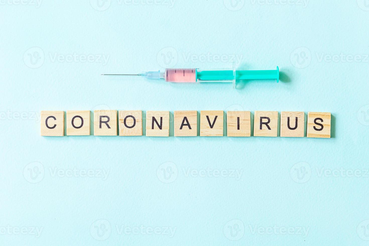 textphrase coronavirus und spritze auf blauem pastellhintergrund. neuartiges coronavirus 2019-ncov mers-cov covid-19 respiratorisches syndrom des nahen ostens coronavirus-virus-impfstoffkonzept. foto
