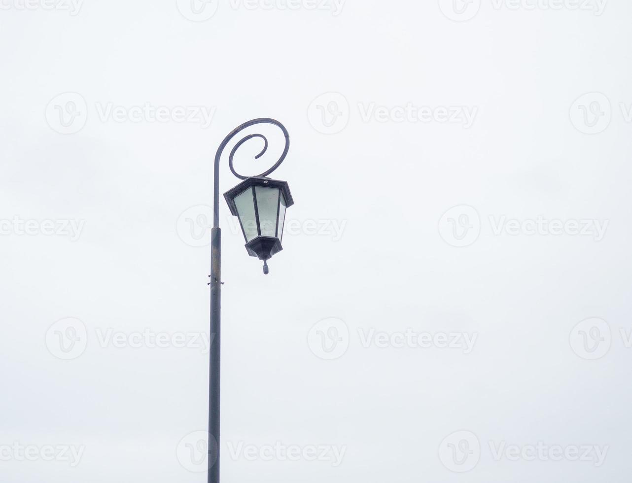 eine schöne Straßenlaterne auf dem Hintergrund eines grauen Himmels. gemusterter Lampenschirm. foto