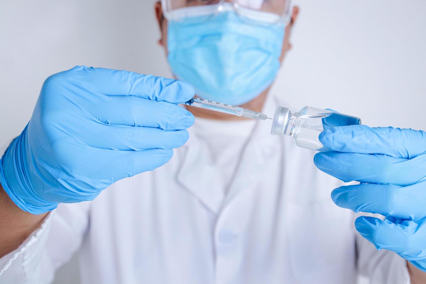 Ärzte oder Wissenschaftler halten Spritzen und Fläschchen mit dem Covid-19-Impfstoff, um Injektionen zur Behandlung von Patienten in Krankenhäusern zu versuchen. Medizinische Experimente verhindern die Ausbreitung des Coronavirus foto