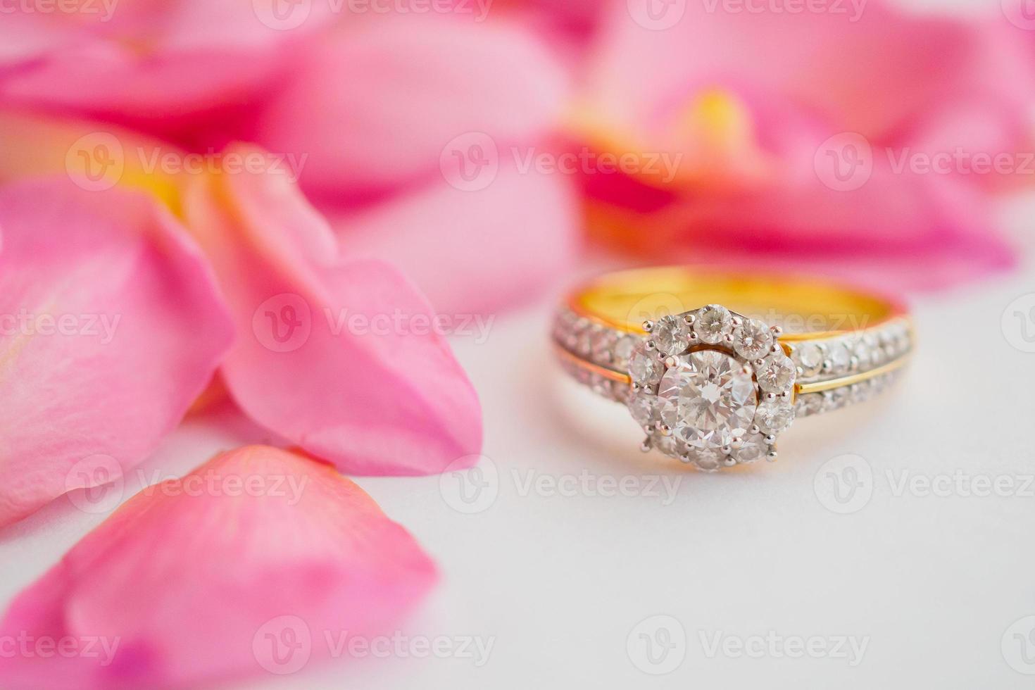 Schmuck-Diamant-Ring auf weißem Hintergrund mit schönen rosa Rosenblüten hautnah foto