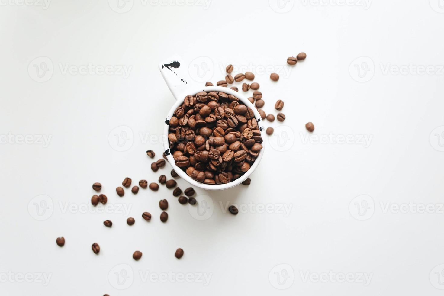 weißer Keramikbecher voller Kaffeebohnen foto