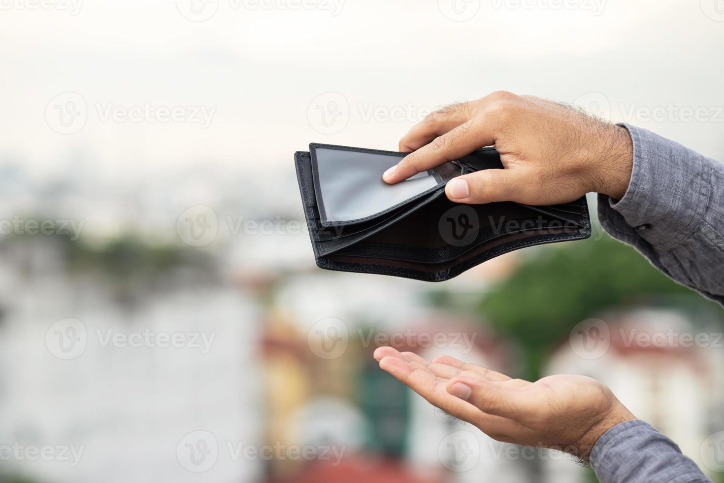 eine leere Brieftasche in den Händen eines jungen Mannes foto