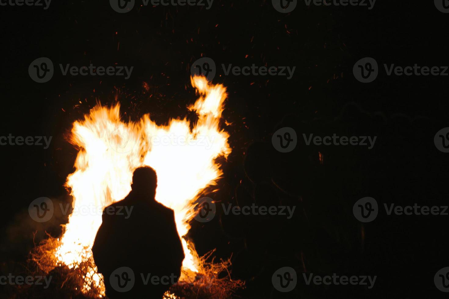 Silhouette Mann steht vor Feuer foto