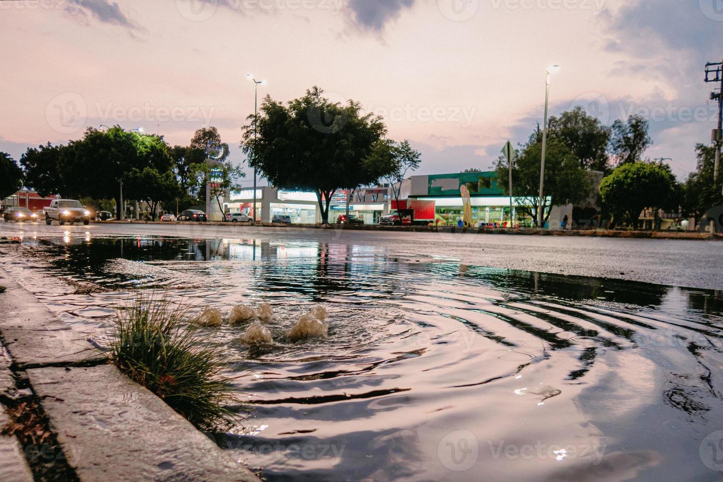 Wasser sprudelt aus dem Straßenablauf foto