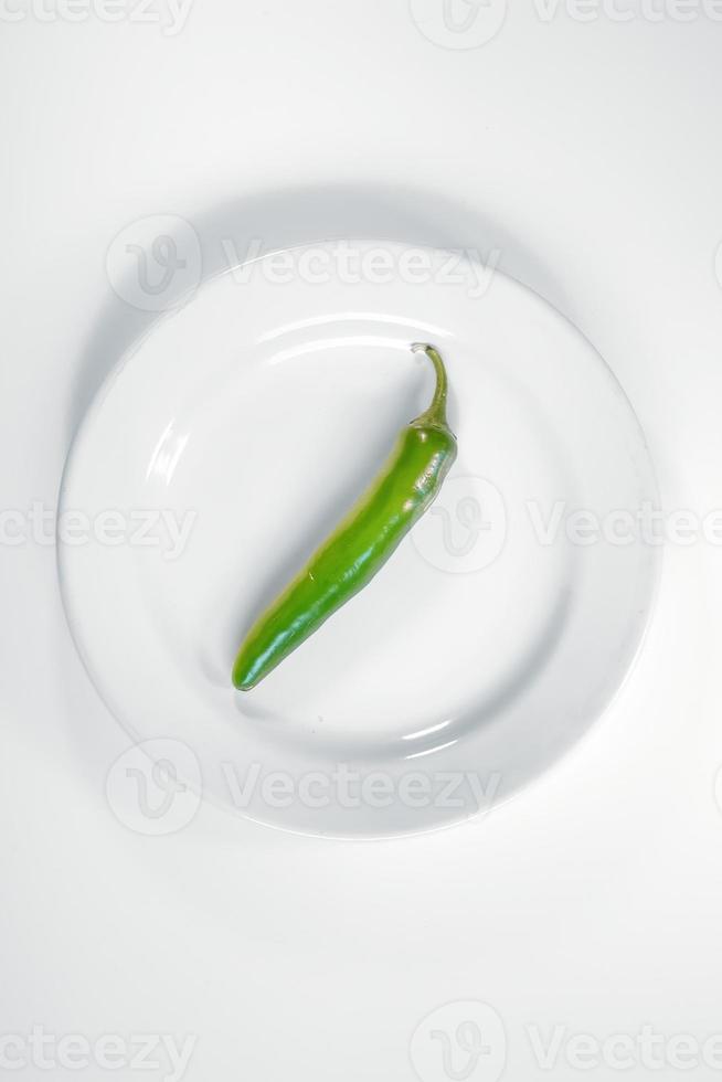 grüne Chilischoten auf einem weißen Teller foto
