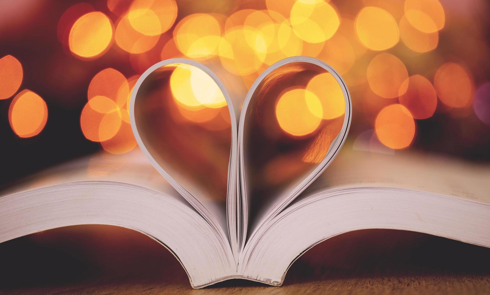 Buchseiten in Form eines Herzens mit Bokeh-Hintergrund foto