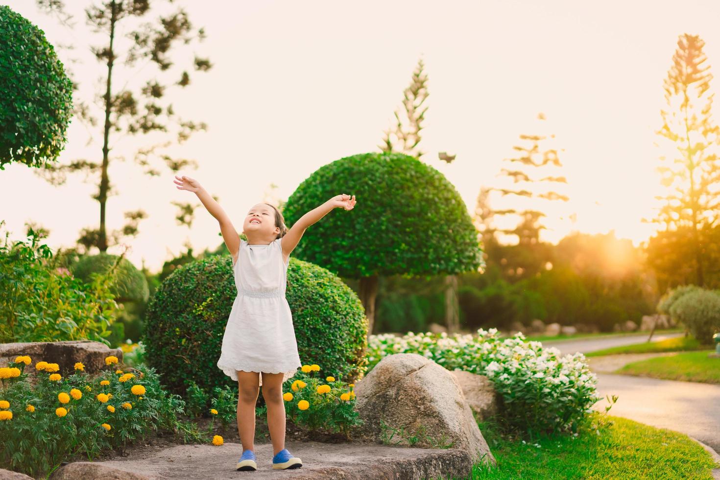 junges Mädchen öffnet im Sommer die Arme zum Himmel foto