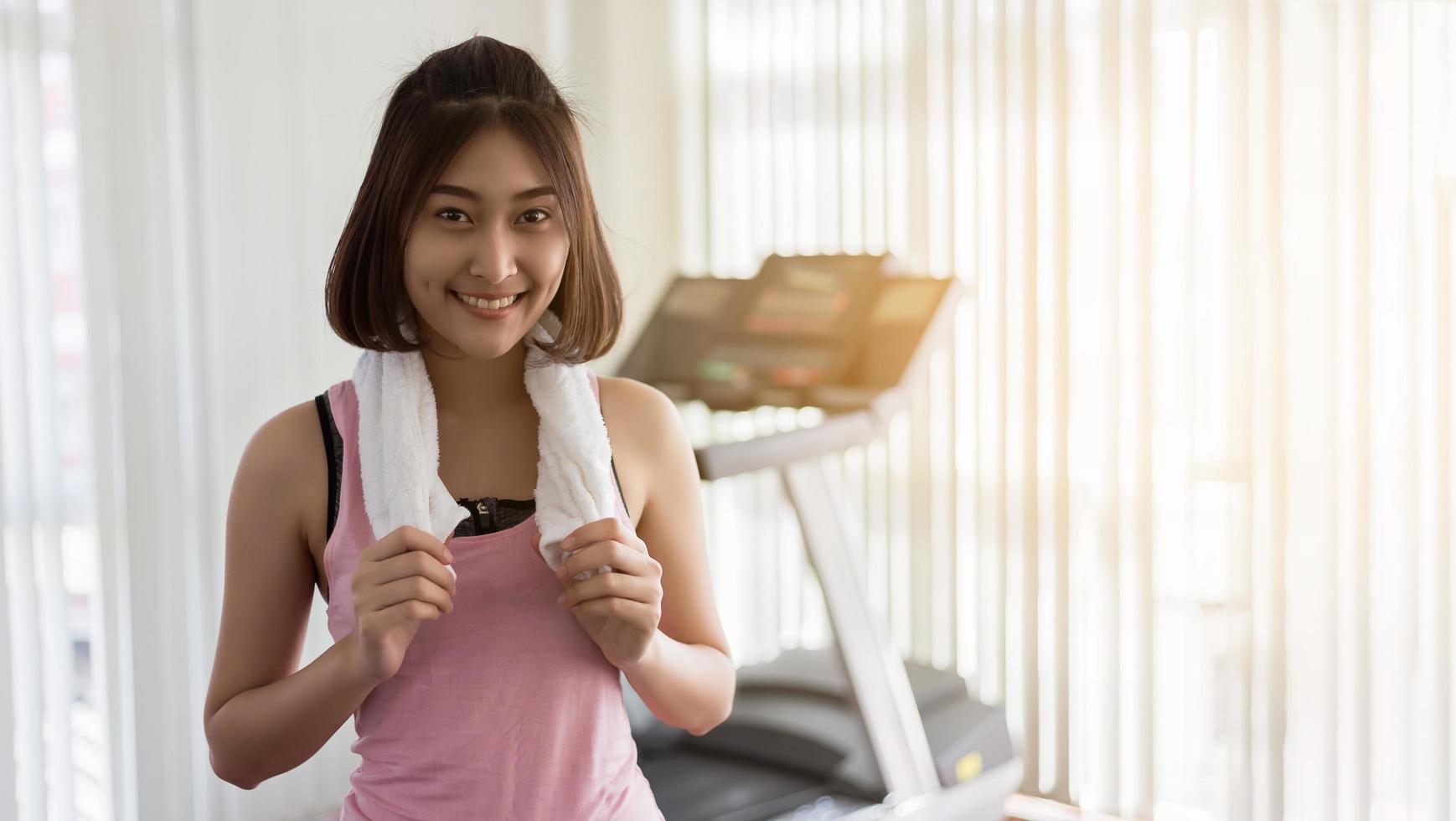 Frau vor dem Laufband im Fitnessstudio foto