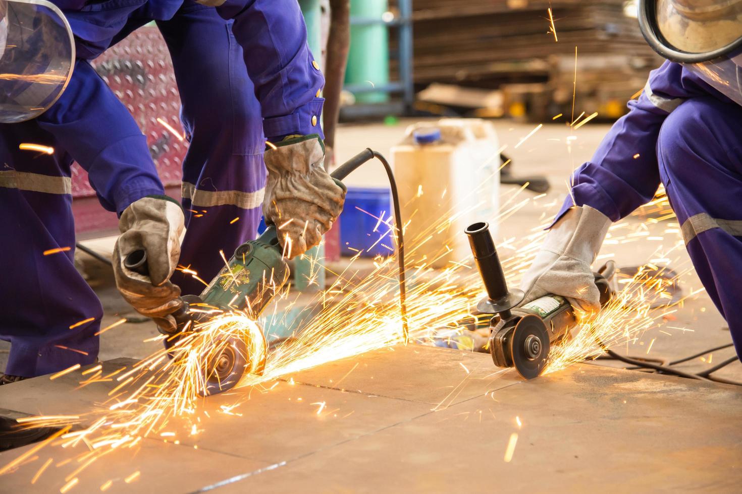 Arbeiter schneiden Bleche mit Elektroschleifer foto