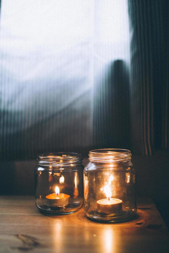 zwei Kerzen brennen in Gläsern foto