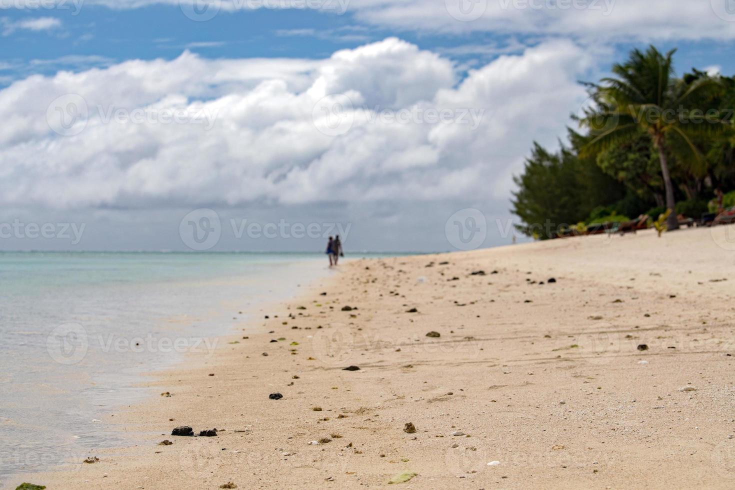 mann und frau, die am strand von polynesien spazieren gehen foto