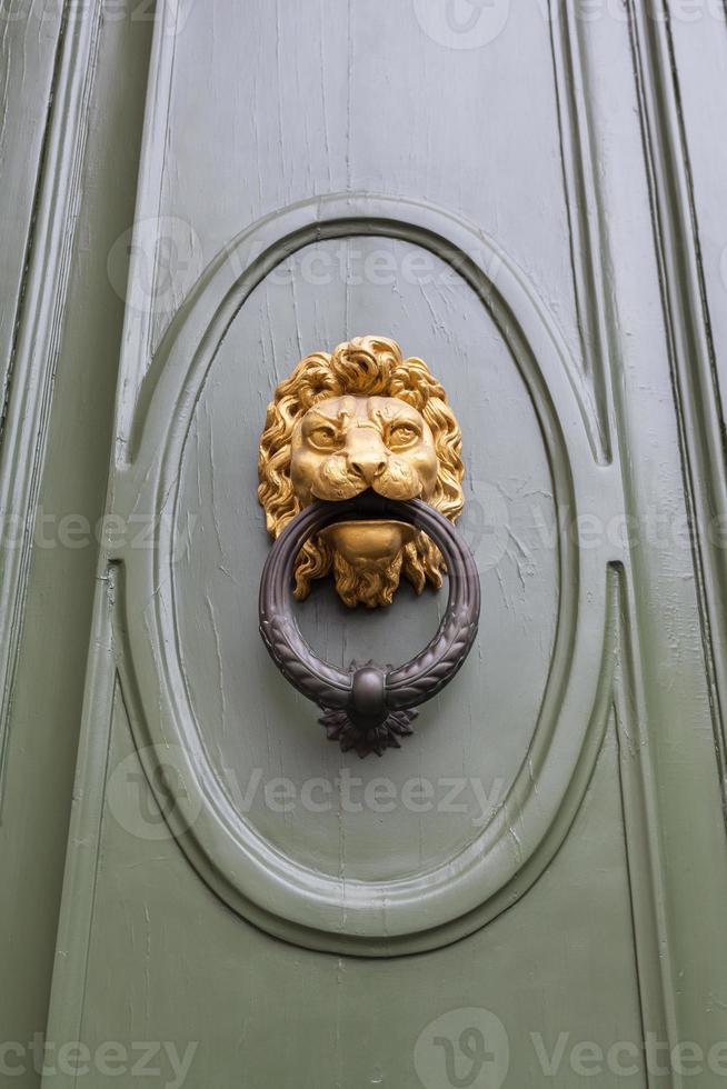 Löwenkopfklopfer an grüner Tür in Florenz foto