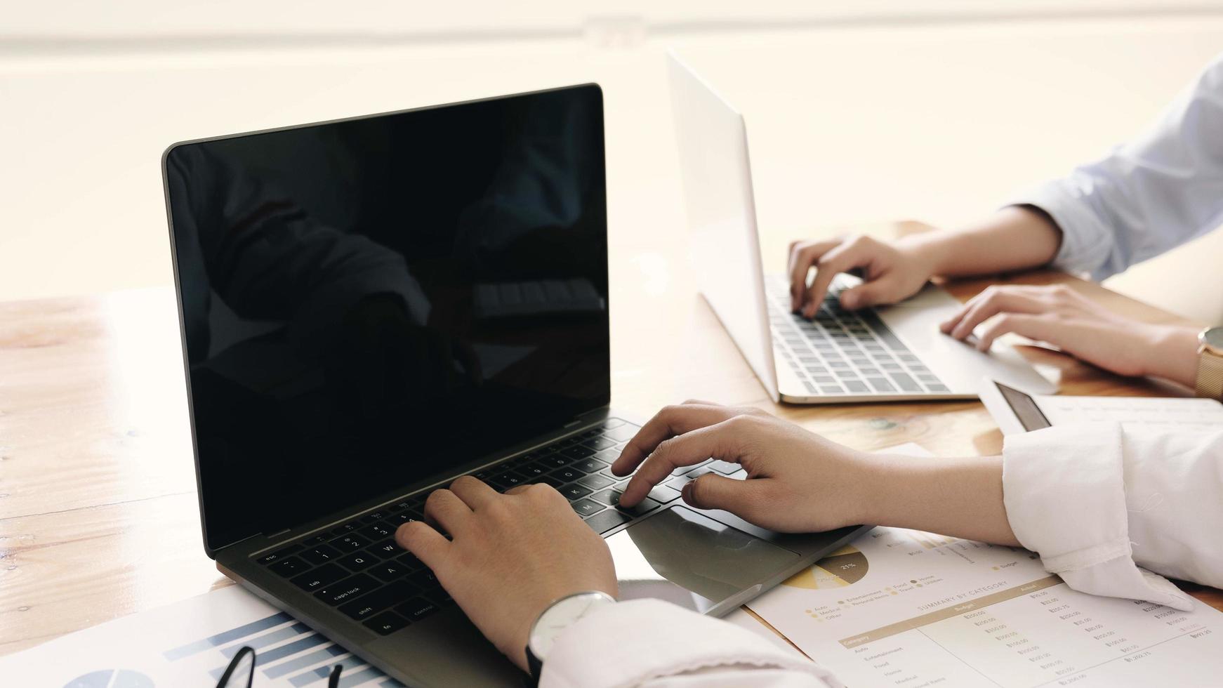 zwei Leute arbeiten an Laptops foto