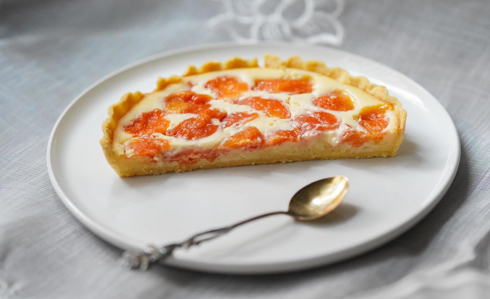 Torte mit Fruchtscheiben auf Keramikplatte foto