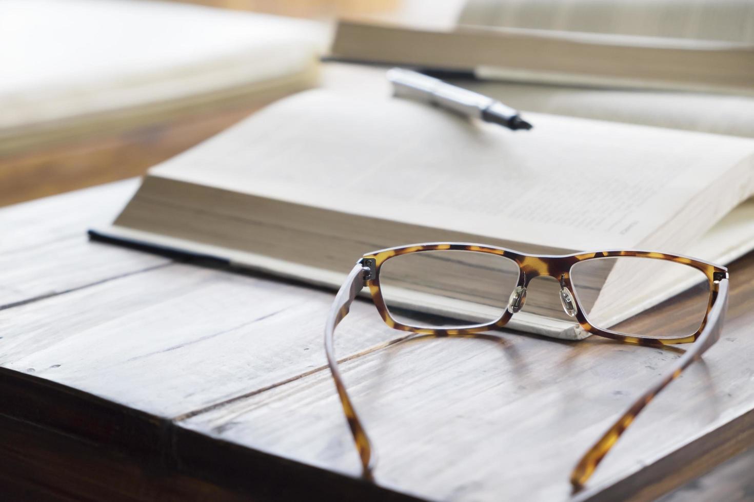 Nahaufnahme der Lesebrille neben dem Buch foto