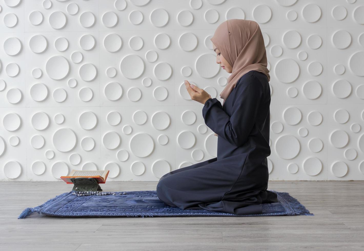 muslimische Frau kniet im Gebet foto