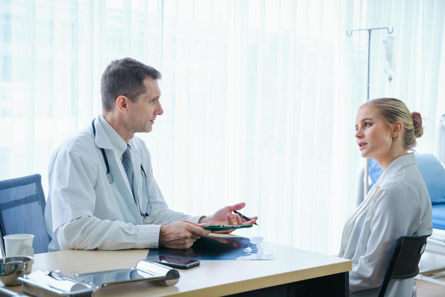 Arzt bespricht die Pflege mit dem Patienten foto