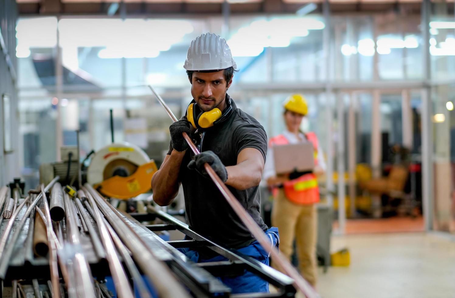 Techniker, der Kupferrohr am industriellen Arbeitsplatz hält foto