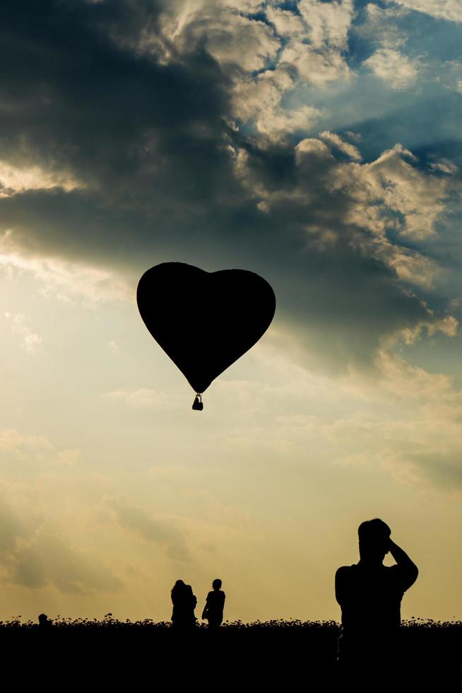 Silhouetten von Touristen und Heißluftballon foto