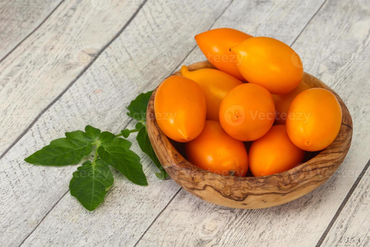 gelber Tomatenhaufen in der Holzschale foto