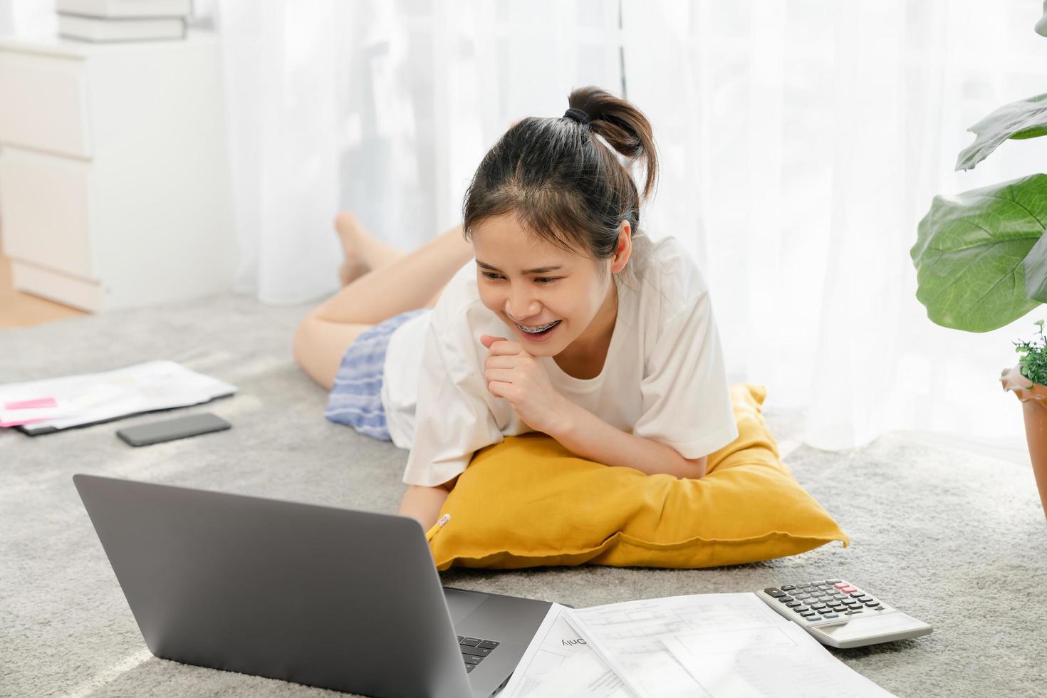 Frau arbeitet am Laptop auf dem Boden foto