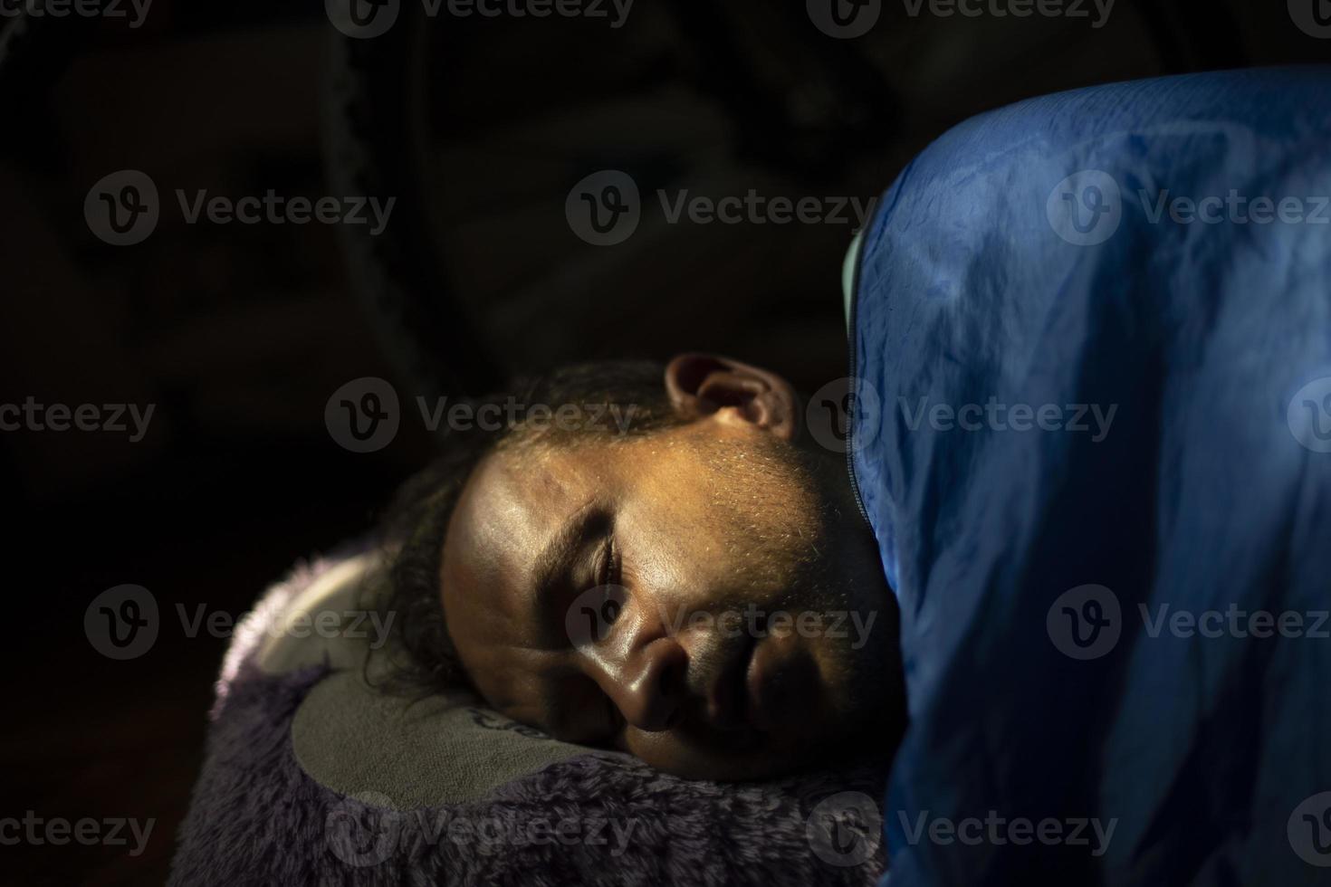 Kerl schläft morgens. Mann schläft tief unter der Decke. junger Mann liegt im Sonnenlicht. foto