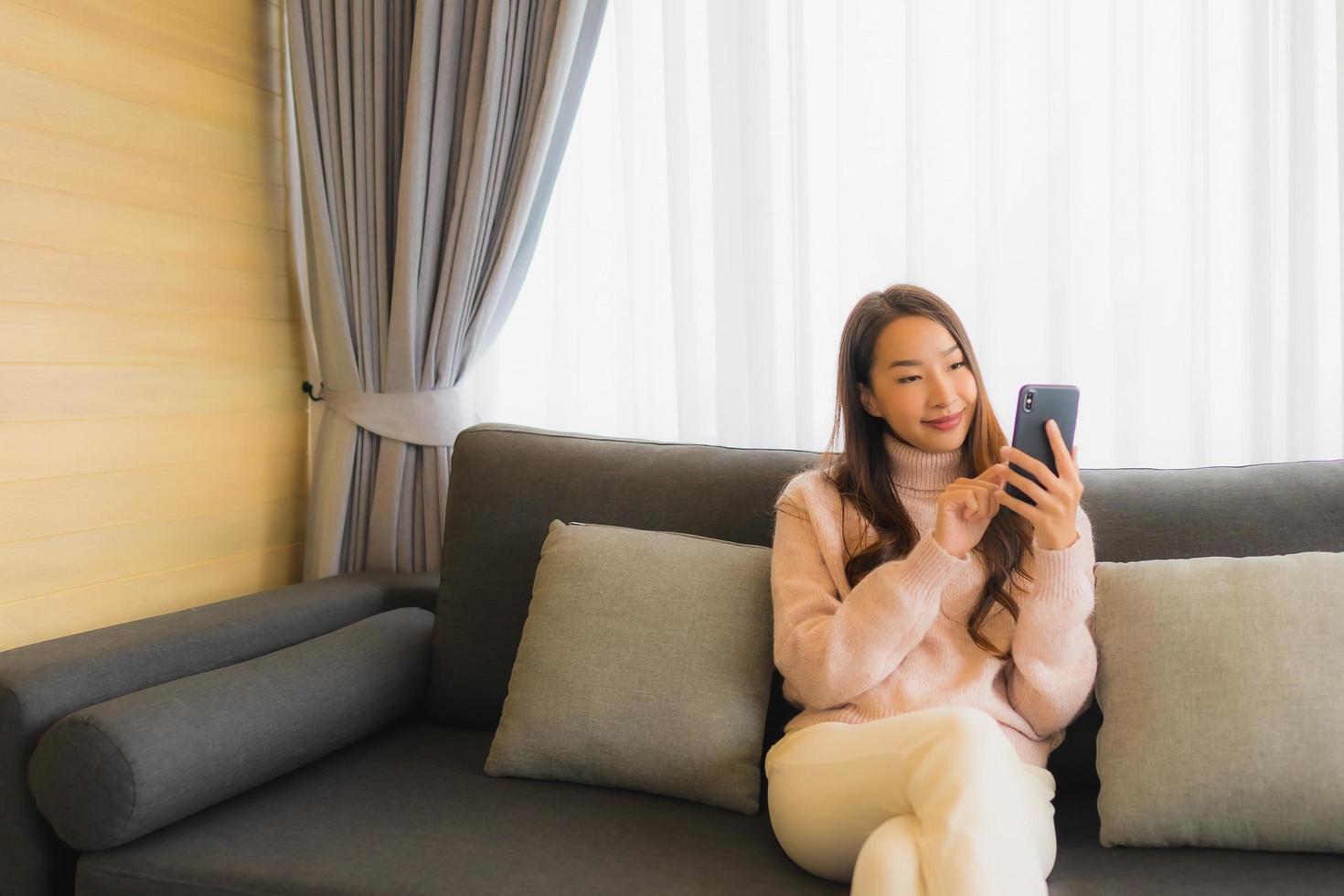 Frau, die auf Sofa am Telefon entspannt foto