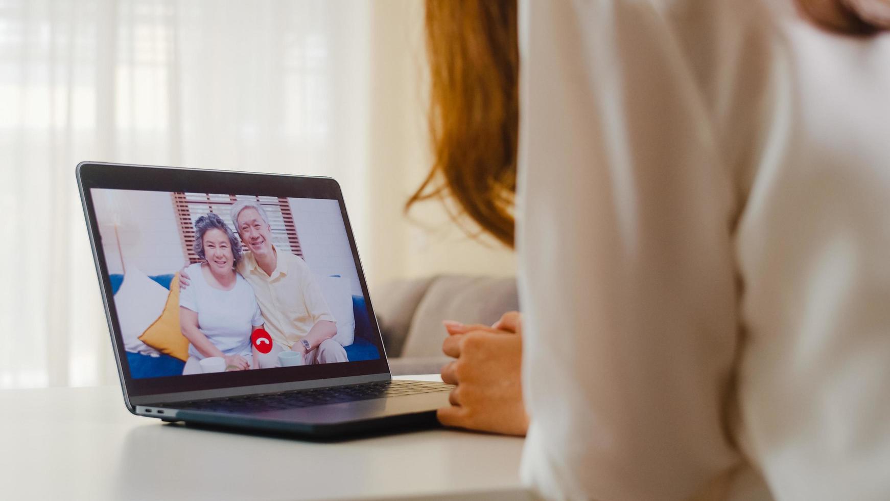 junge asiatische Frau mit Laptop-Videoanruf mit Familie. foto