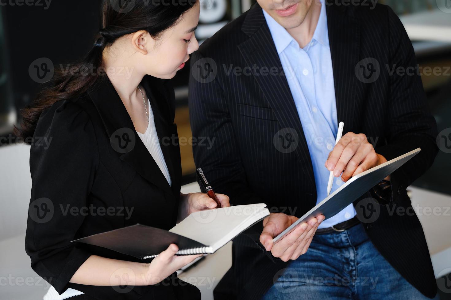 Bei der Beratung zeigt ein männlicher Berater mit einem Stift auf ein Tablet, um den Unternehmerinnen die Gewinnumstrukturierung zu erklären. foto