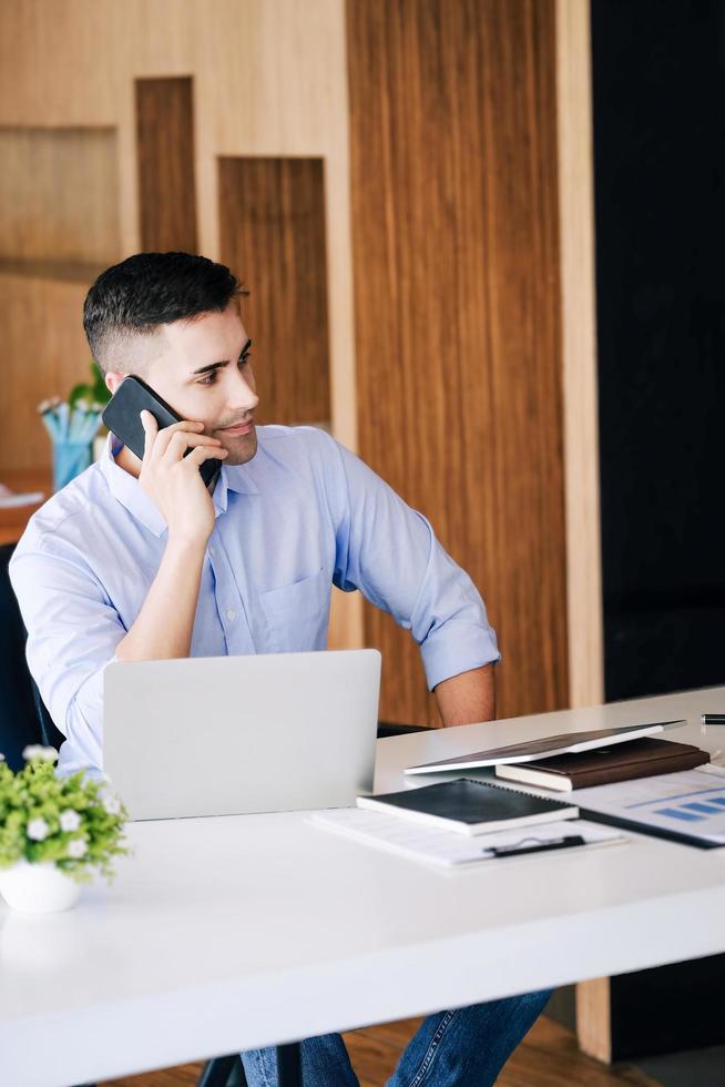 männlicher marketingmanager, der telefoniert, um mit risikokapitalunternehmen zu sprechen, um das gewinnpotenzial zu steigern. foto