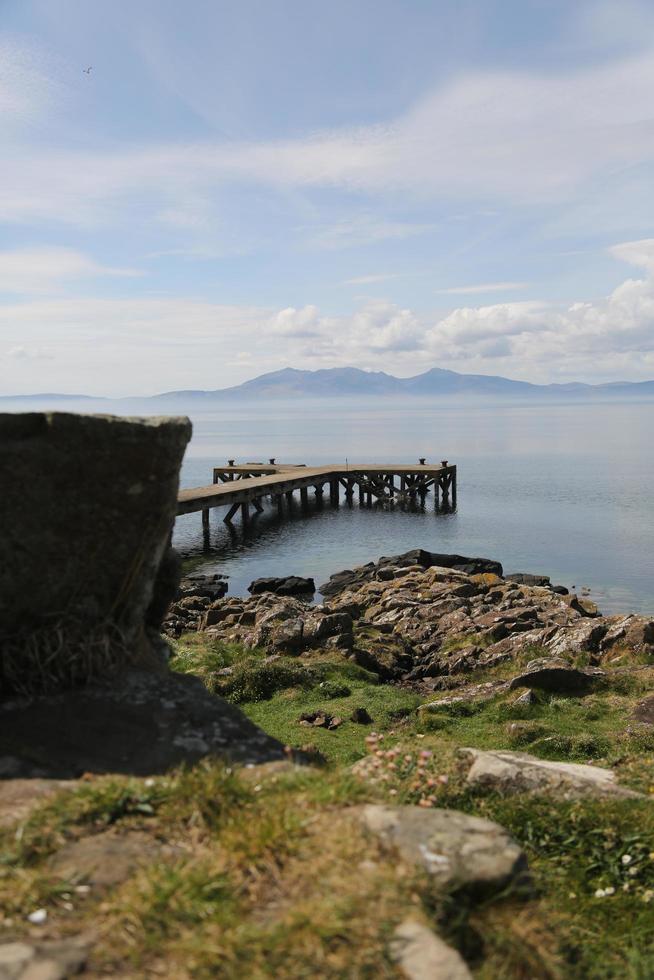 Gras, Strand, Dock, Wasser und Berge foto