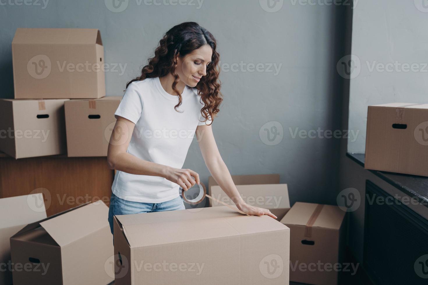 weiblich versiegeln kartonpaket mit klebeband am umzugstag. Umzugsservice, Umzug foto