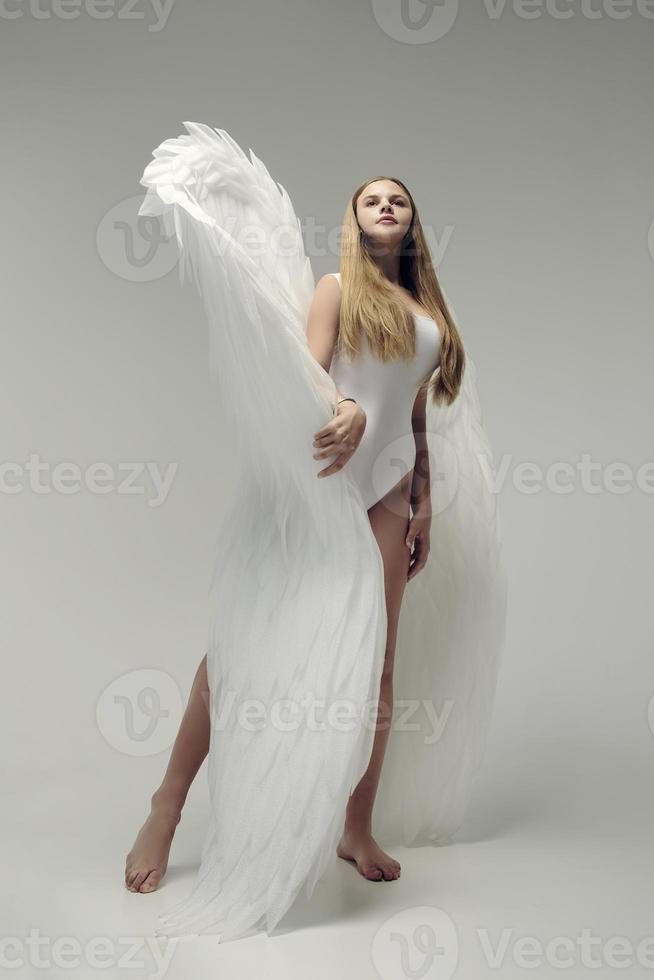 ein romantisches Engelsmädchen in einem weißen Body mit weißen Flügeln foto