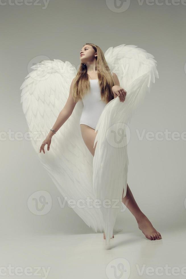 ein romantisches Engelsmädchen in einem weißen Body mit weißen Flügeln foto