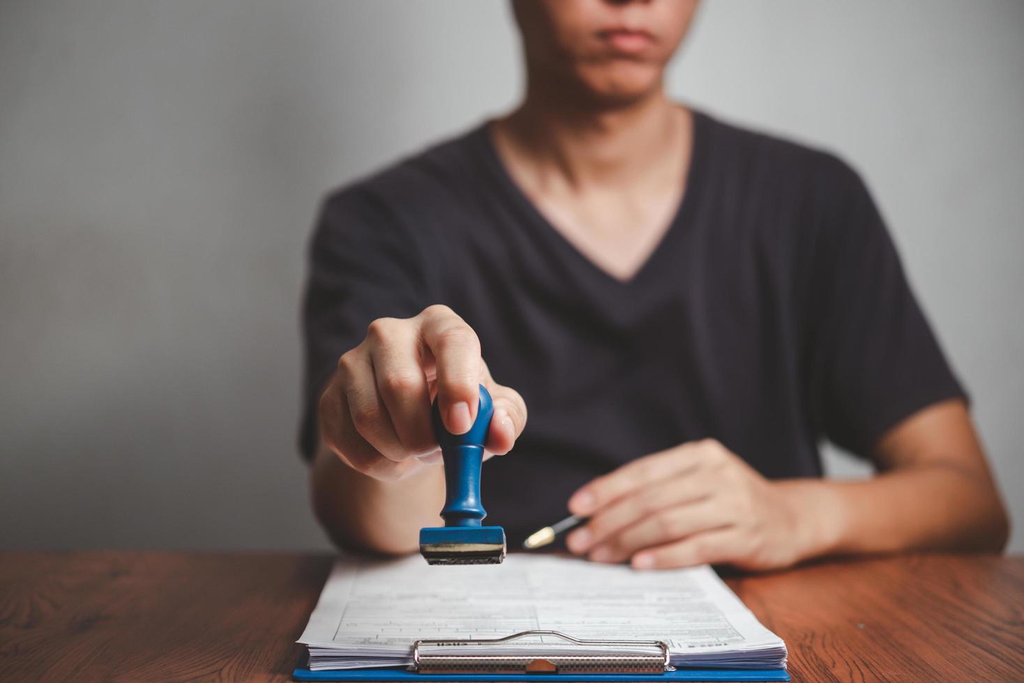 unterschreiben genehmigung protokoll dokumente stempel bestätigung beruf unterschrift. Geschäftsmann Hand stempeln Papier Arbeitskonzept finanzieren. foto