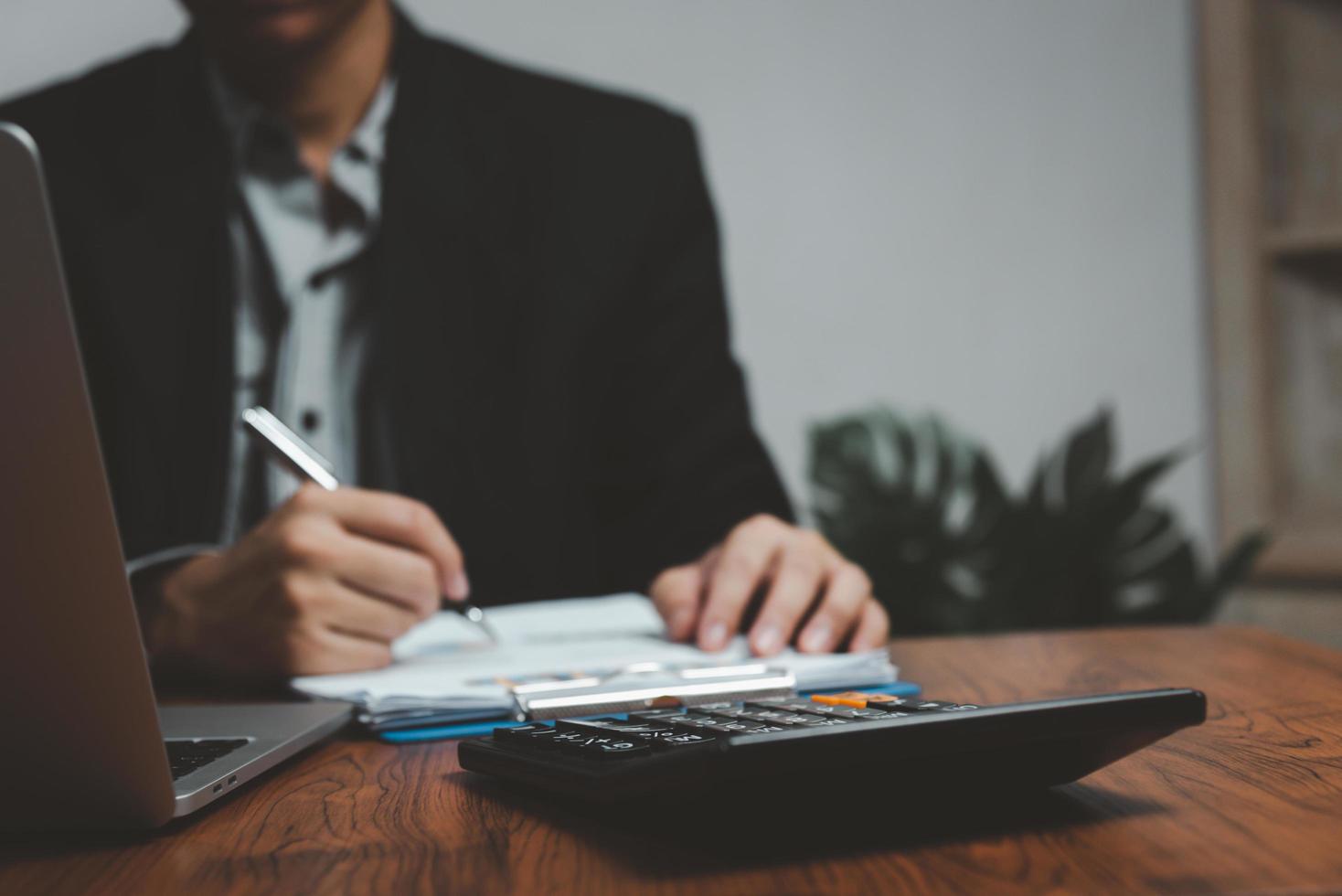 Hand mit Stift schreiben Papierkram Geschäftsdokument Finanzinvestition oder Unterschrift Vertrag Job und Versicherung auf dem Schreibtisch. foto