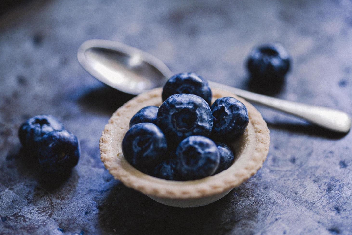 Schüssel Blaubeeren mit Löffel foto