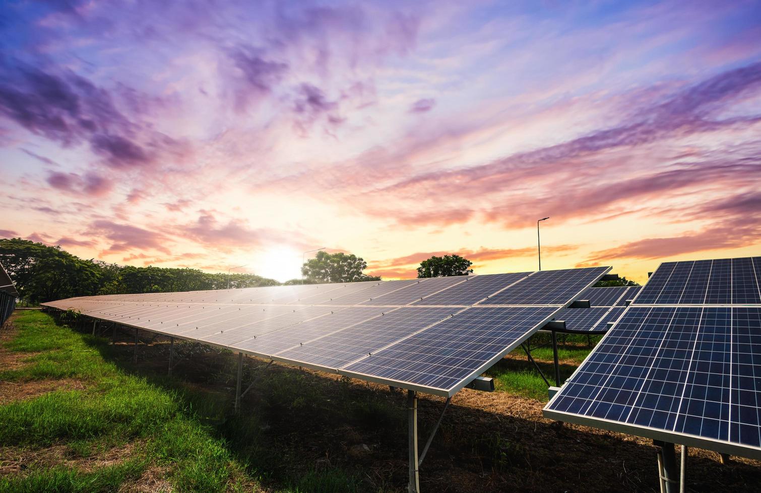 Solarpanel-Zelle auf dramatischem Sonnenuntergangshimmelhintergrund foto