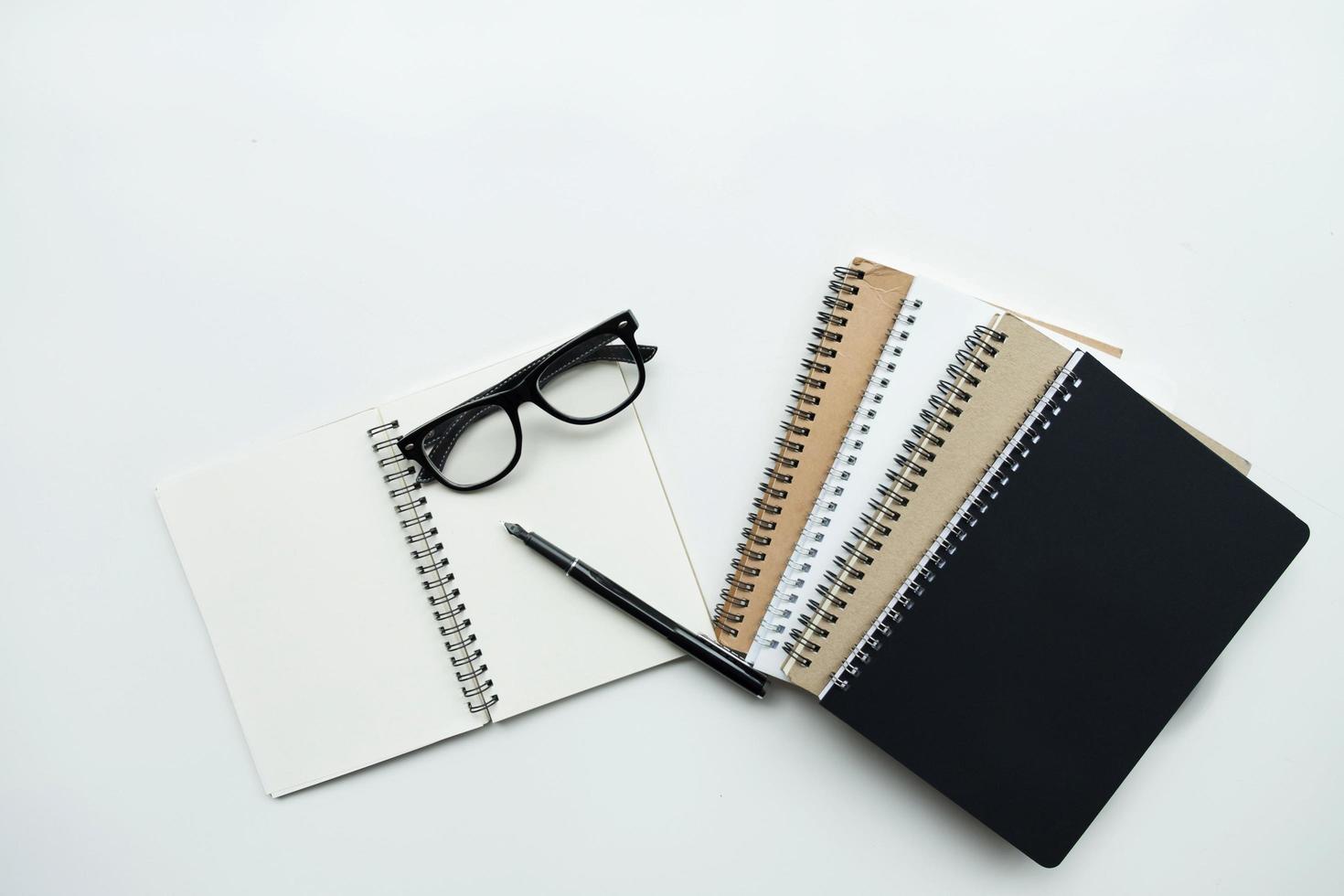 Notizbücher mit Stift und Brille foto