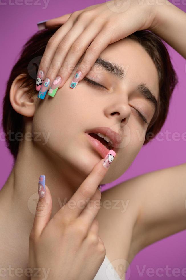 liebevolles hübsches mädchen mit kurzem haarschnitt und extravaganter nagelkunst foto