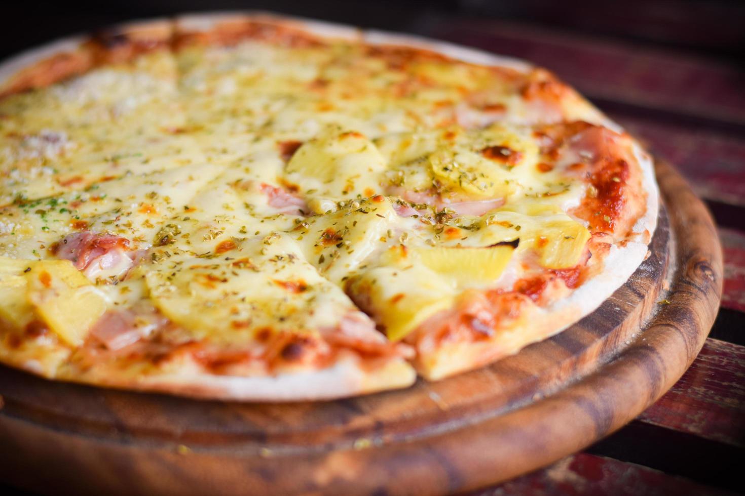 Pizza Hawaii-Käse auf Holztisch. hausgemachtes Essenskonzept foto