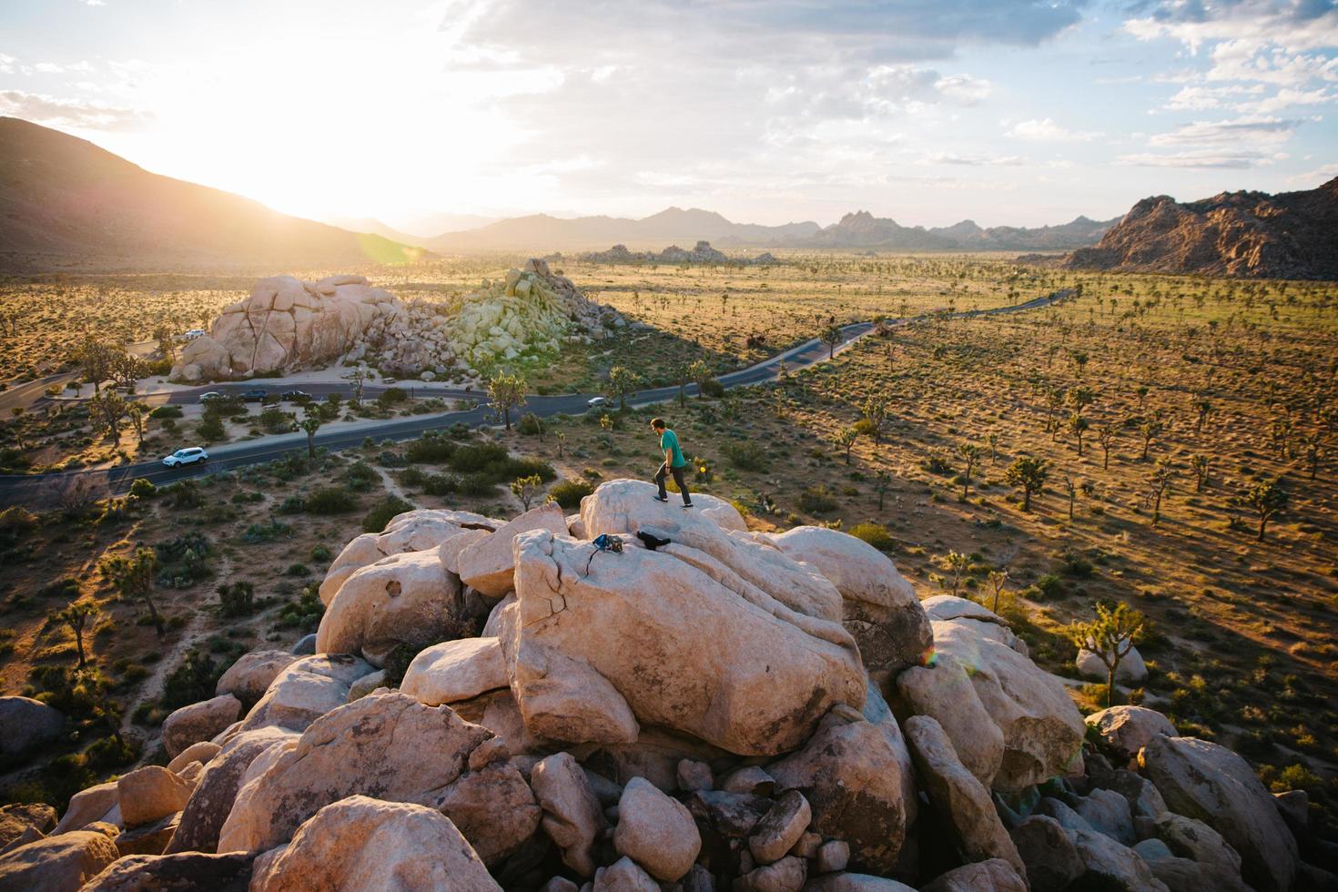 Mann, der auf Felsenhaufen im Joshua Tree National Park geht foto