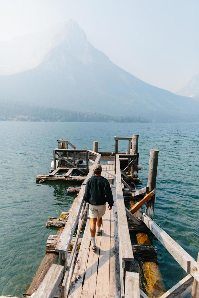 Mann, der auf Dock im Gletschernationalpark geht foto