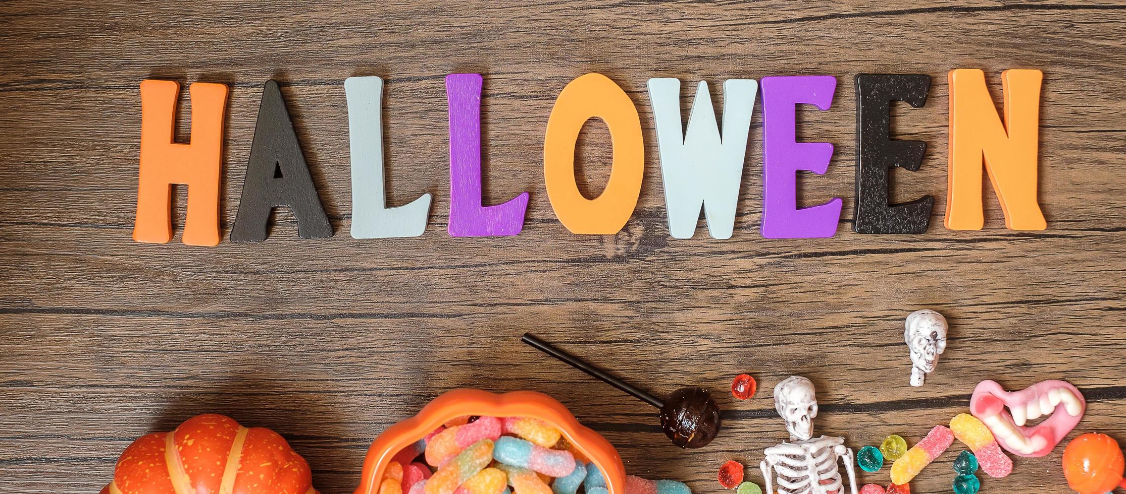 fröhlicher halloween-tag mit geisterbonbons, kürbis, schüssel und dekorativ. trick oder bedrohung, hallo oktober, herbst, festliches, party- und feiertagskonzept foto