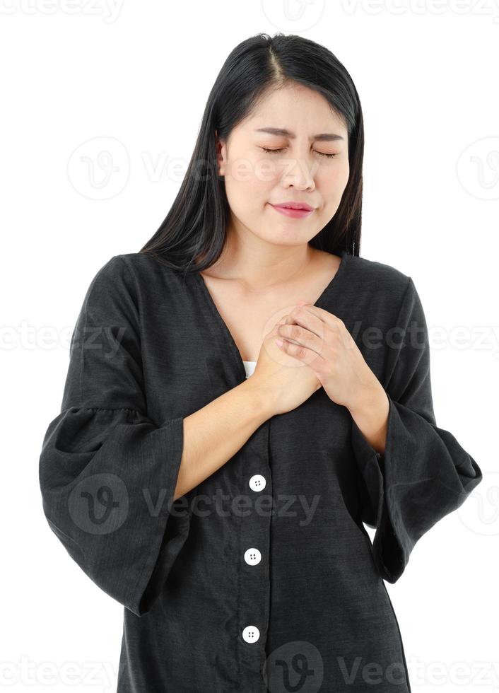 Porträt einer jungen Frau, die ihre Brust hält und einen Herzinfarkt auf weißem Hintergrund hat. Gesundheitskonzept foto