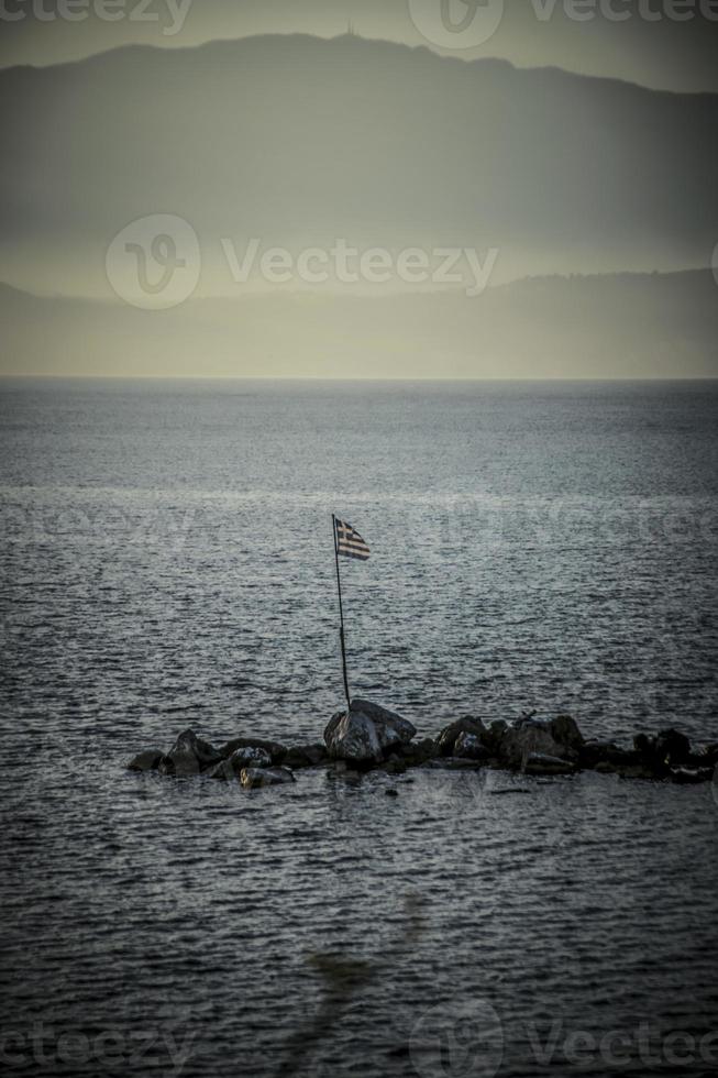 eine griechische flagge im meer bei kefalonia am abend foto