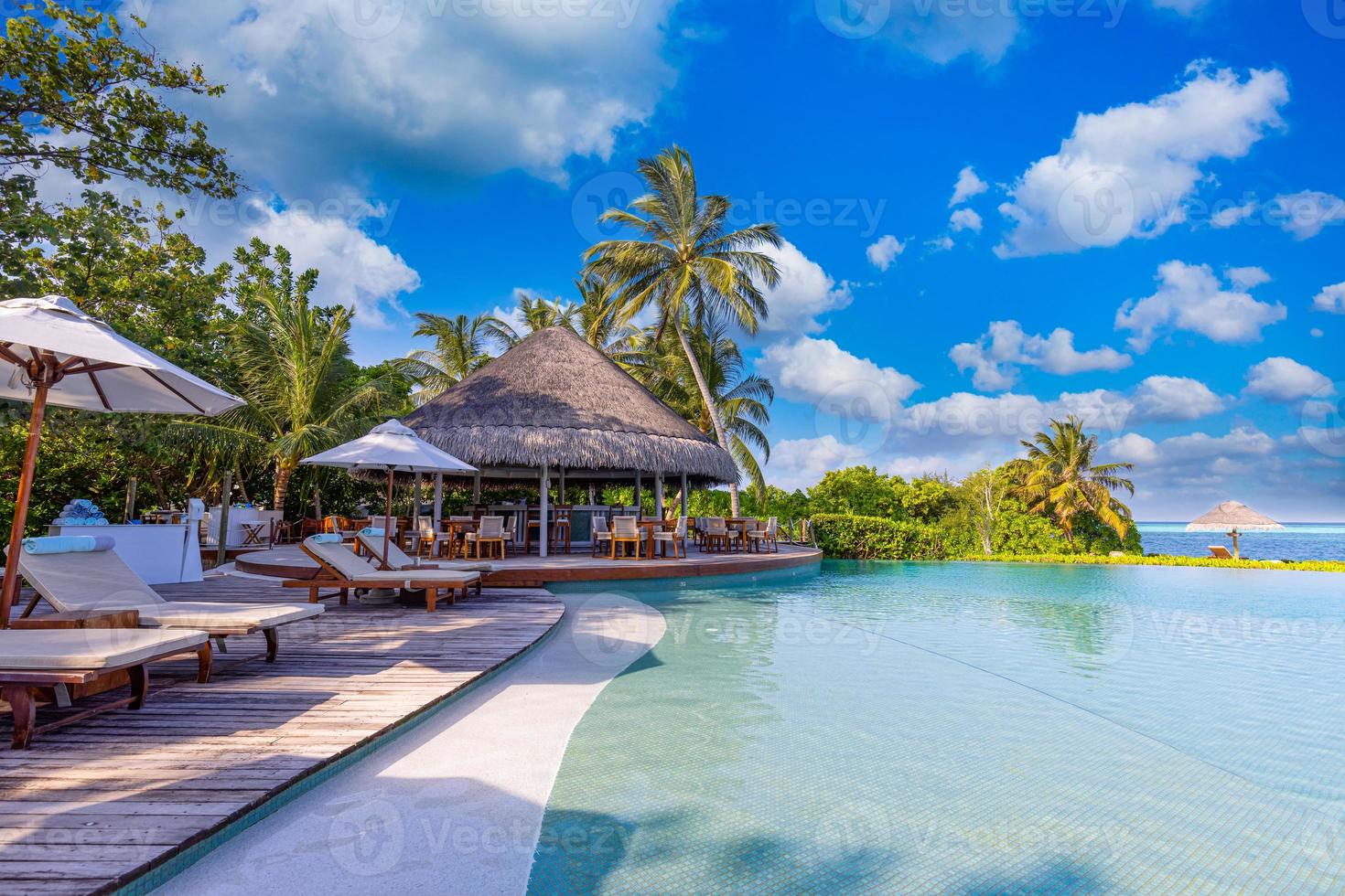 Landschaft des Erholungstourismus. luxuriöses Strandresort mit Spa-Pool und Strandkörben oder Freizeitliegen unter Sonnenschirmen mit Palmenhimmel. sommerreise urlaub hintergrund. Wohlbefinden foto