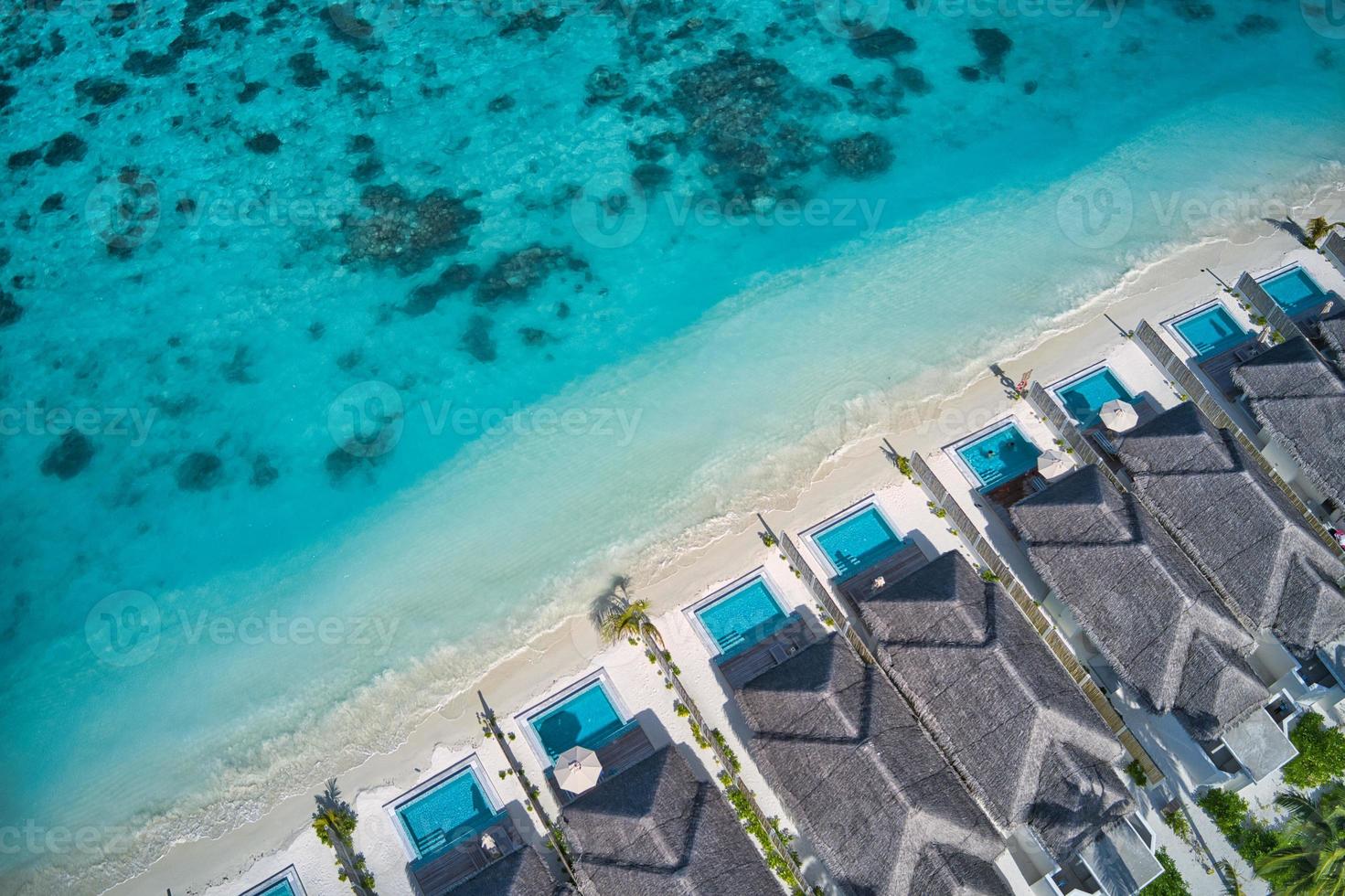 luftdraufsicht auf poolvillen, bungalows am tropischen strand des maledivenparadieses. Erstaunliche blaue türkisfarbene Meereslagune, Meeresbuchtwasser. luxusreise urlaubsziel. schöne sonnige Luftlandschaft foto