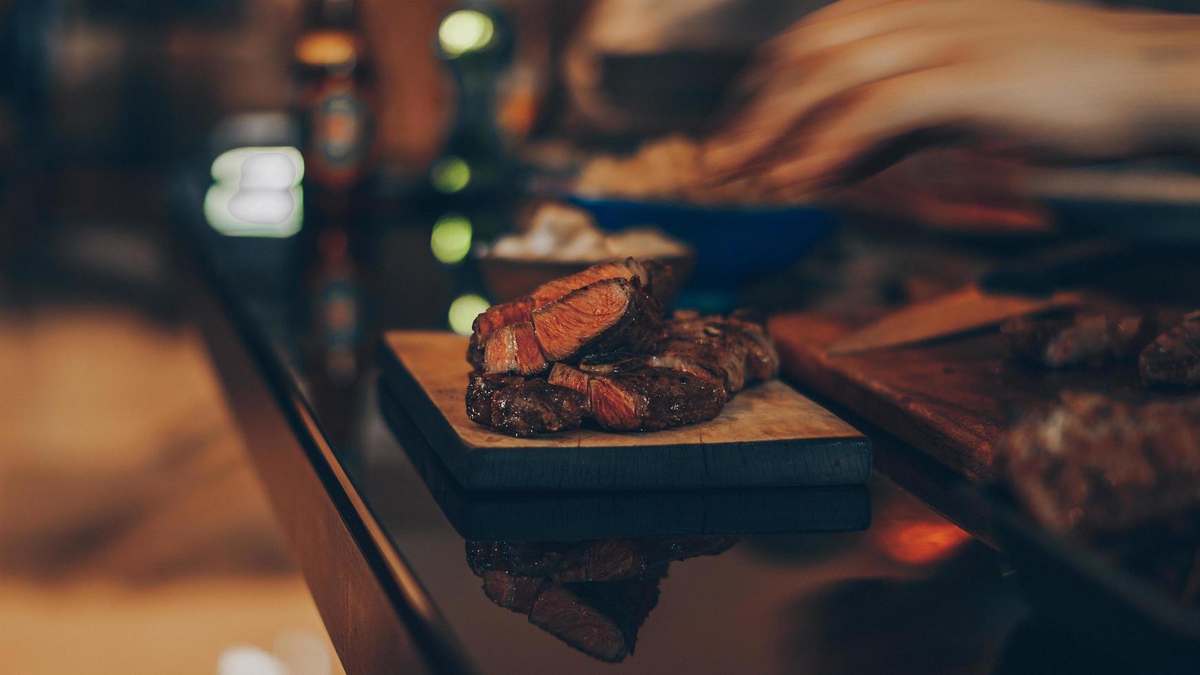 gekochtes Fleisch auf braunem Holzschneidebrett foto